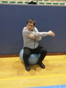 Cliente do CAARPD faz exercício de coordenação postural com bola de ginástica