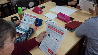 Formandos consultam cartazes informativos sobre o coronavírus